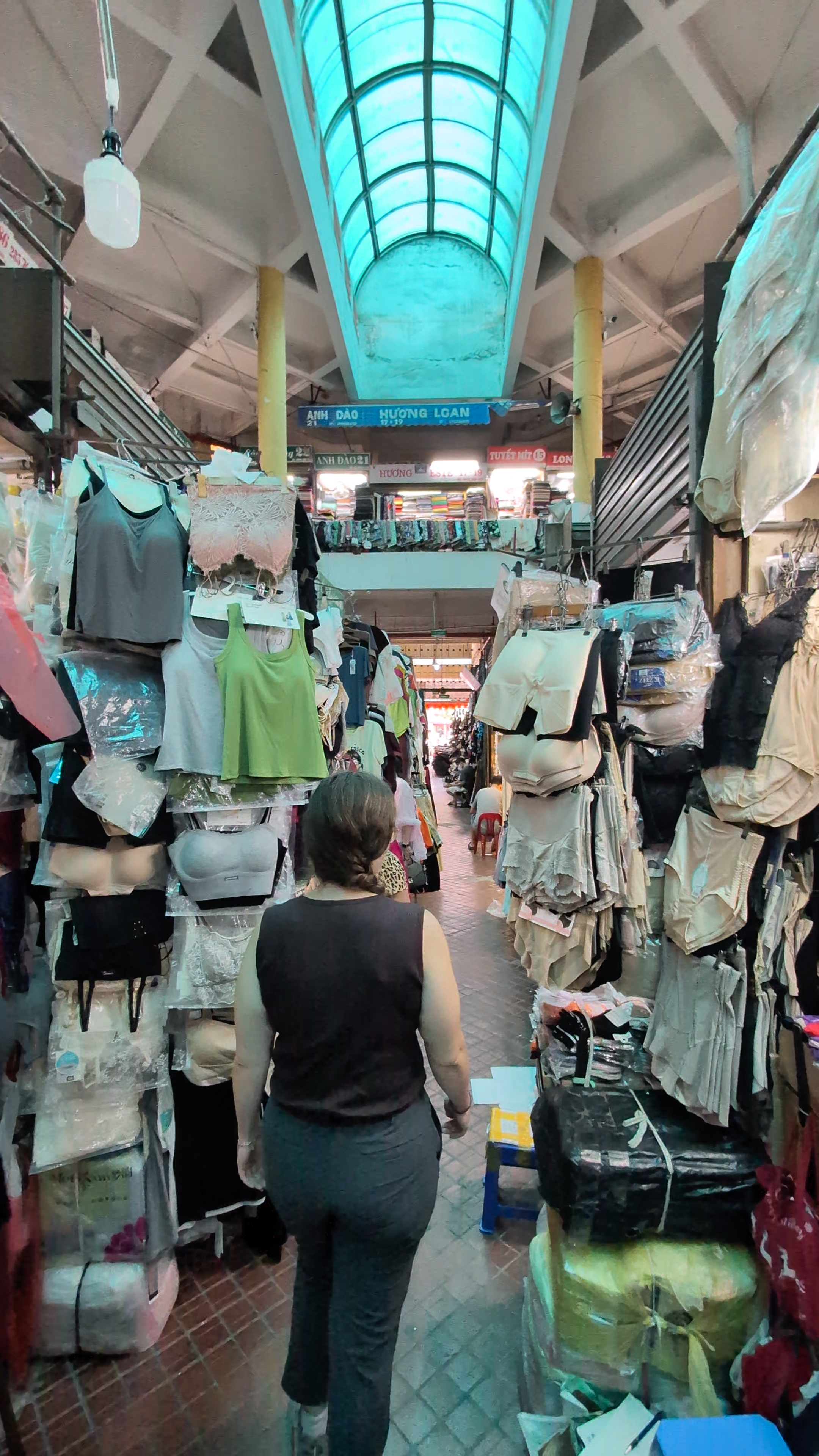 Sarah at Cho Hom local market in Hanoi with locals shopping for shoes and bags