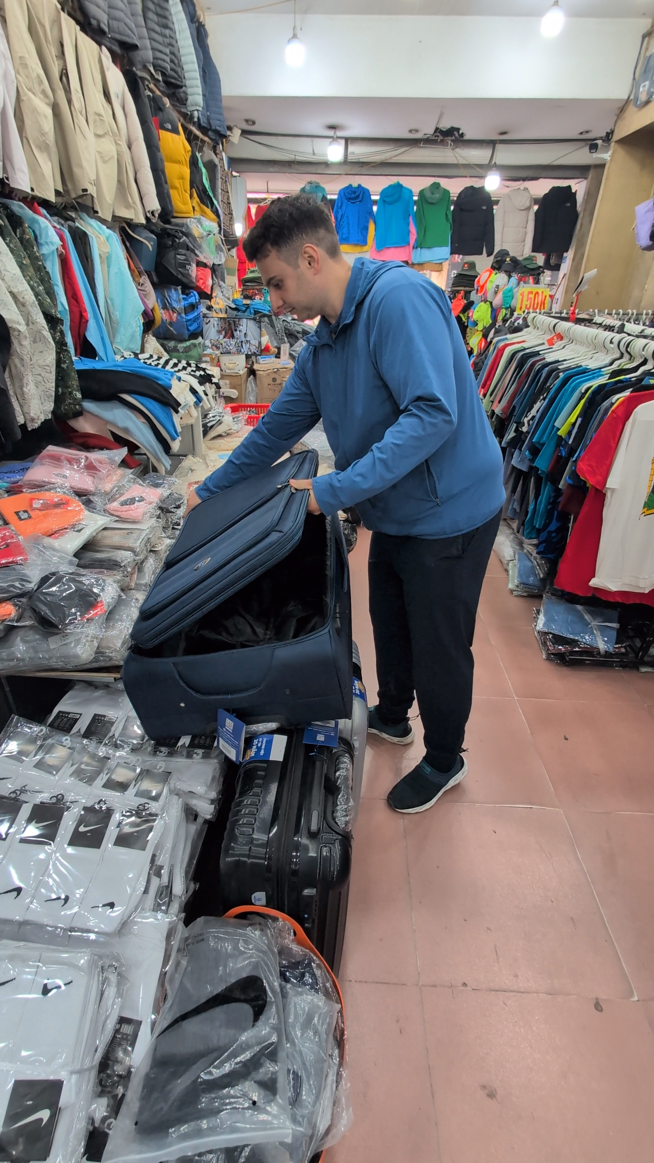 Liam inspecting a suitcase in a market in Hanoi