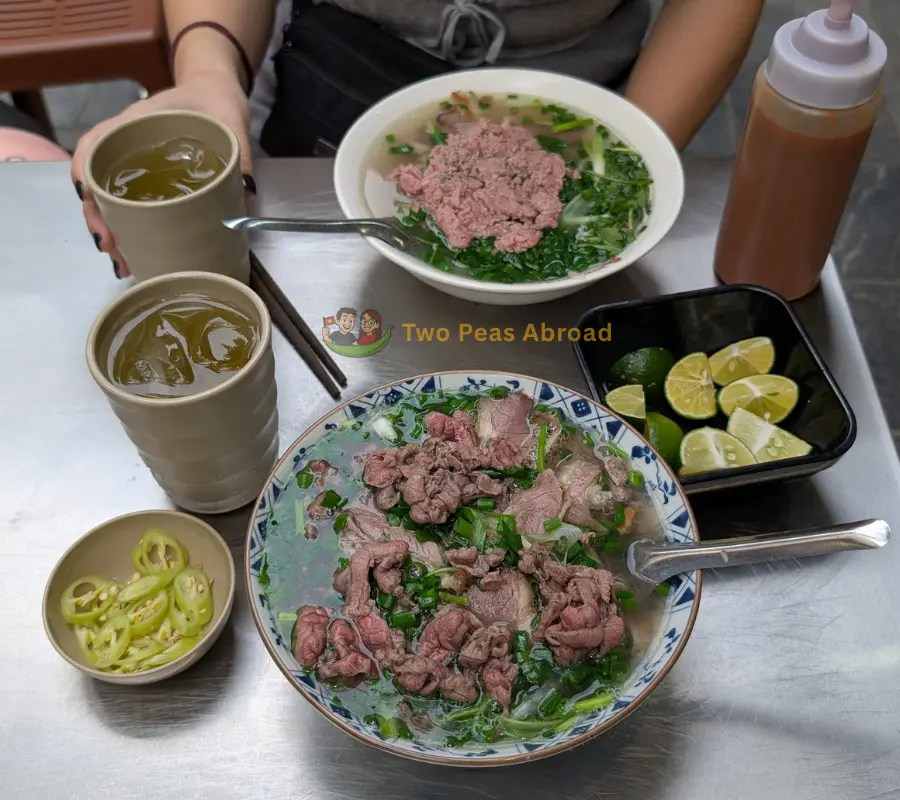 A delicious bowl of local Vietnamese pho from a street vendor on the iconic plastic stools.